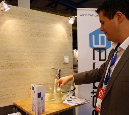 Representante de Métrica6 mostrando el panel con el sistema NESS de ahorro de agua en el stand de SOTEC Granada 2017