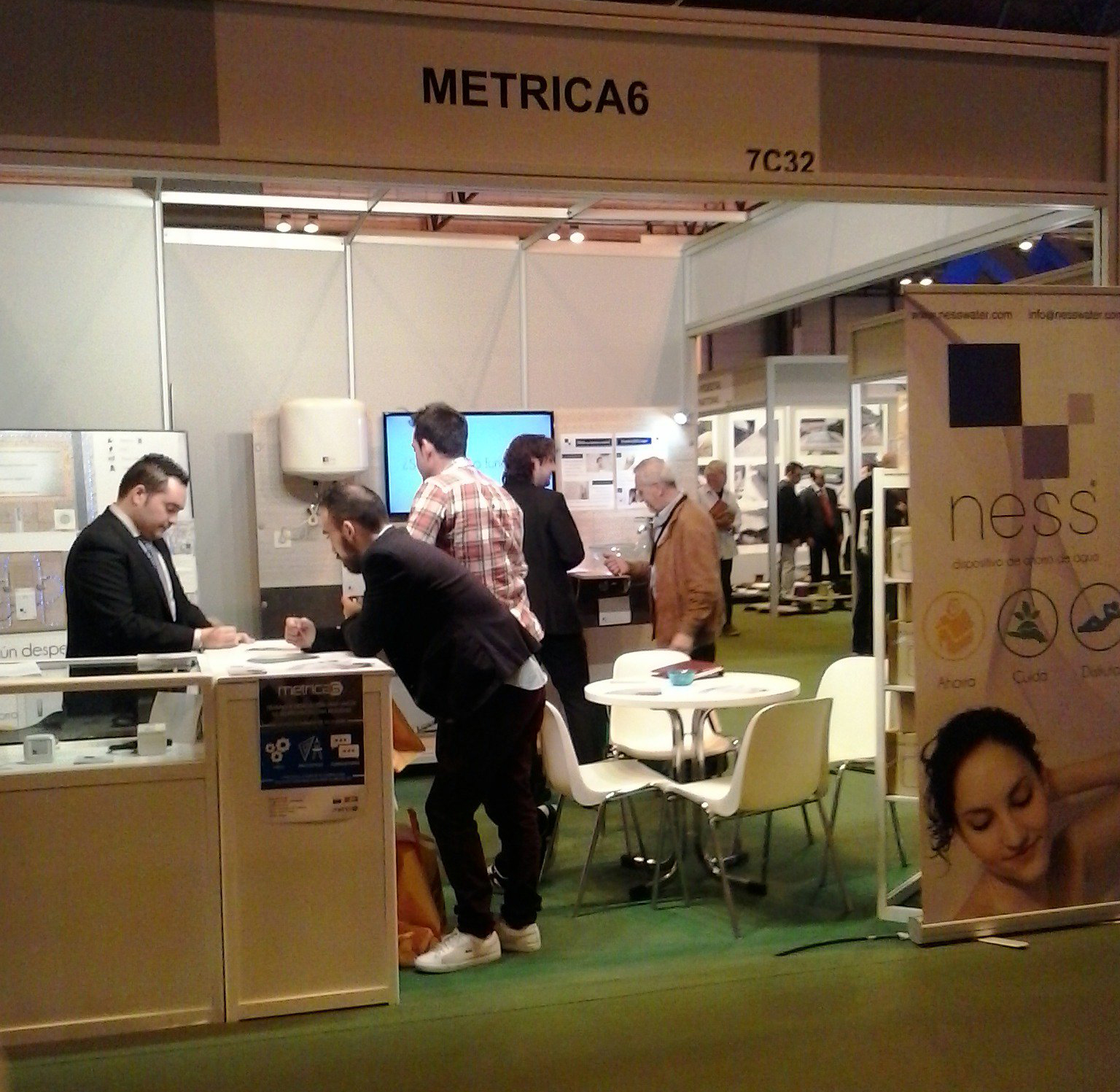 Stand de Métrica6 (7C32) en Construtec 2016 con visitantes interesados en el dispositivo NESS de ahorro de agua – éxito de I+D+i y diseño de producto en la feria de construcción