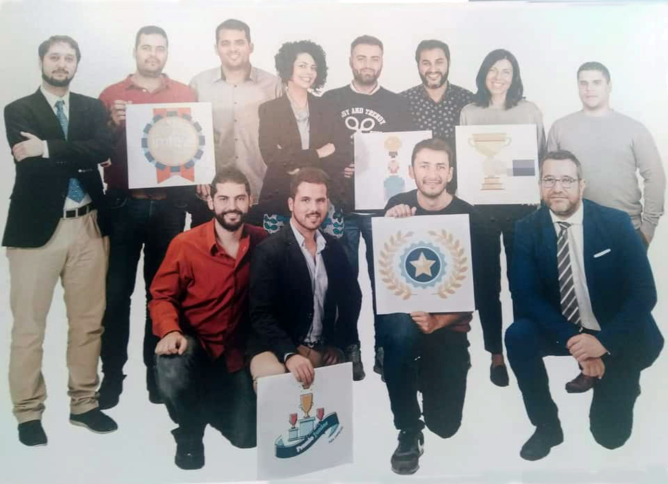 Equipo de Métrica6 con iconos de premios en la exposición de aniversario del Premio Junior Empresas 2017 donde la empresa forma parte de la historia del certamen